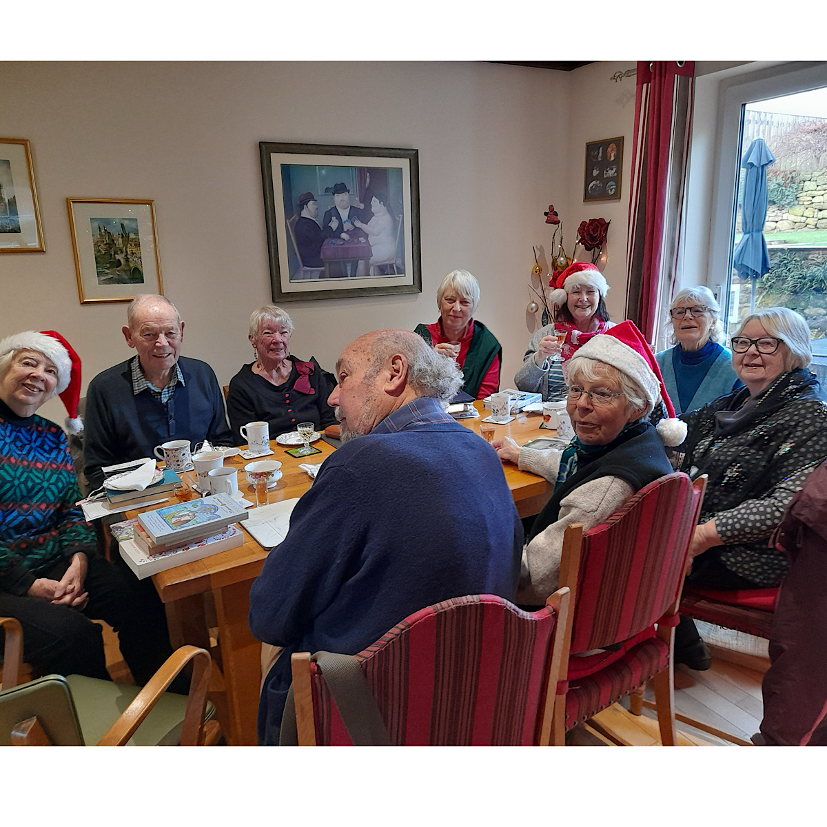 Christmas lunch in a members house with some members wearing festive hats